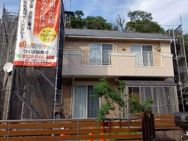 屋根カバー工事を行なう二階建て住宅